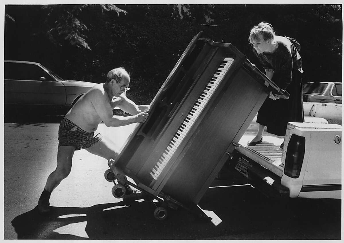 Ed Gong, then 62, moves a piano. The woman on the truck is unidentified. Photo was taken in June 1988.